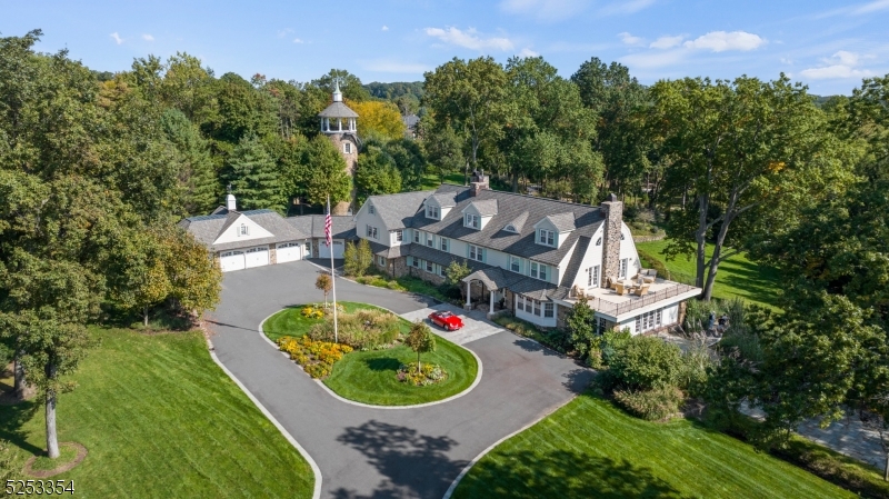 an aerial view of a house with garden space and trees all around