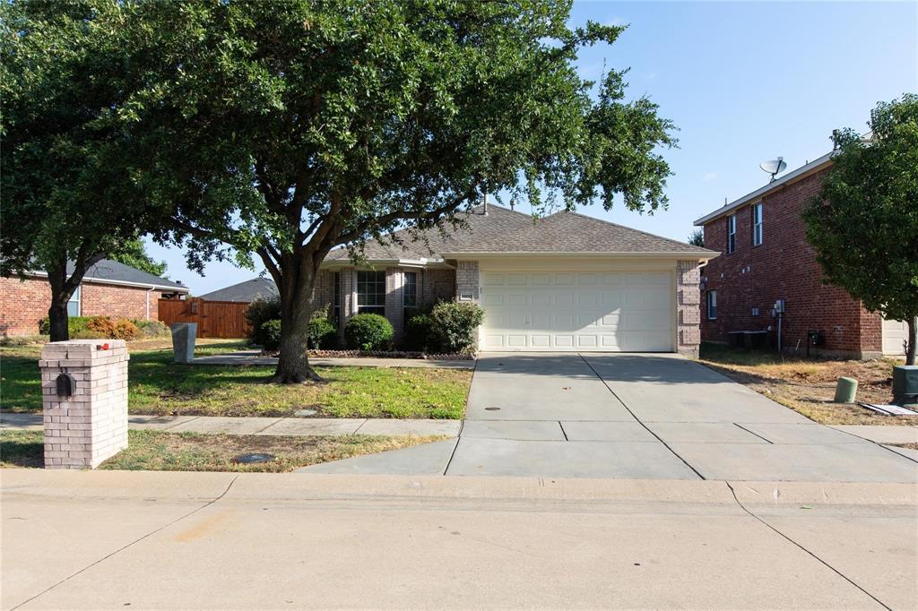 a front view of a house with a yard and trees