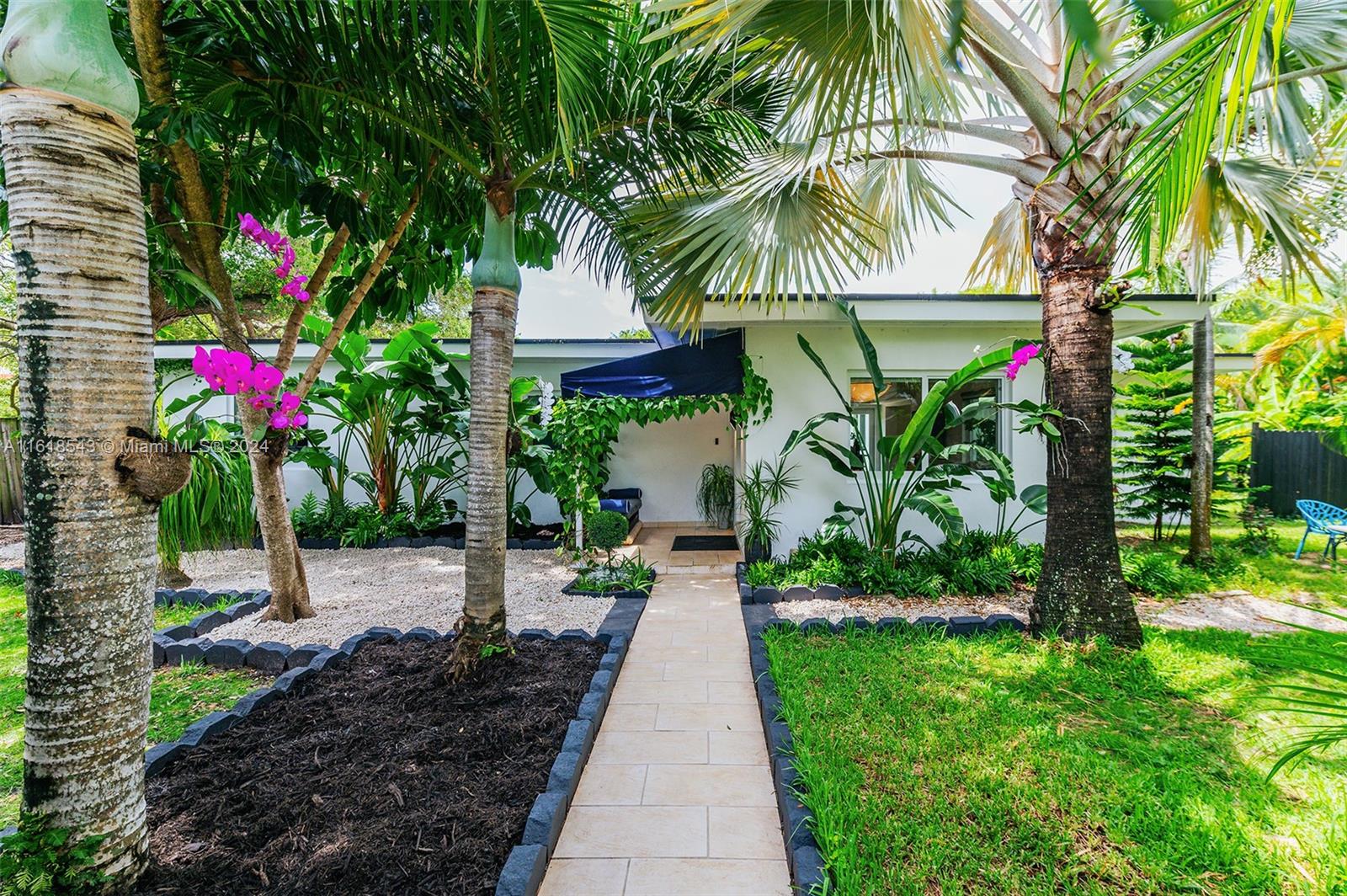 a view of a pathway that has a lot of flower plants