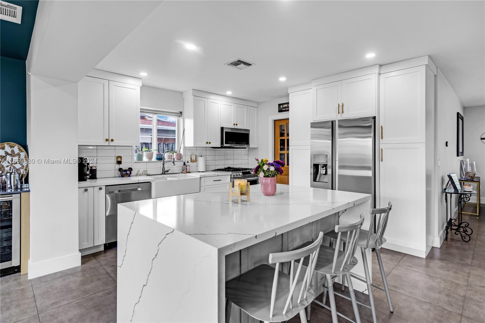 a kitchen with kitchen island a refrigerator stove microwave and cabinets