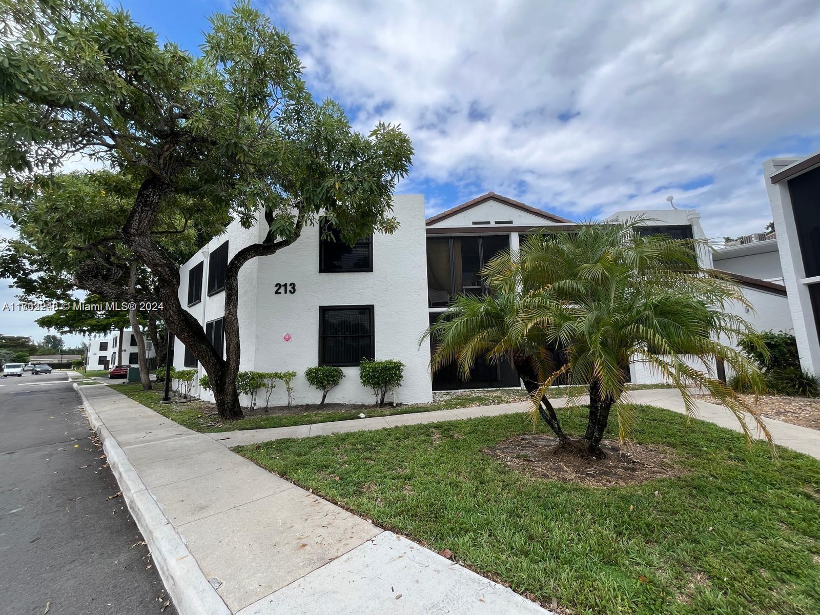 a front view of a house with a yard and trees