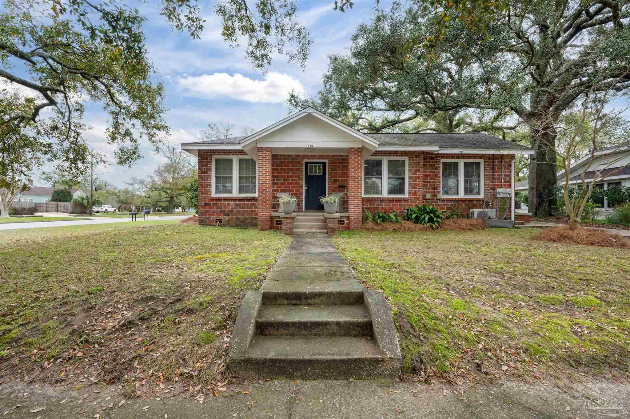 a front view of a house with a yard and trees