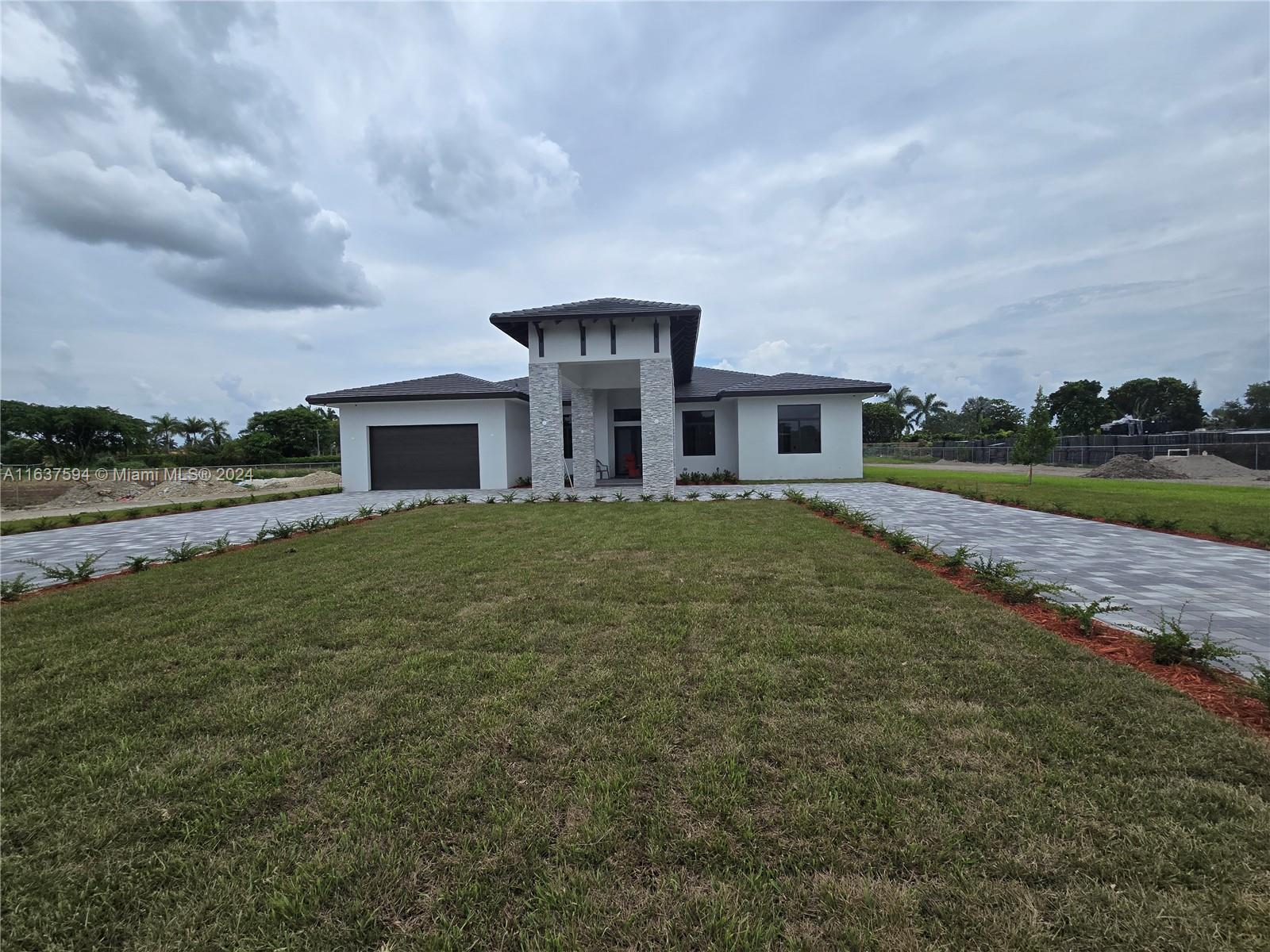 a front view of a house with a yard and lake view