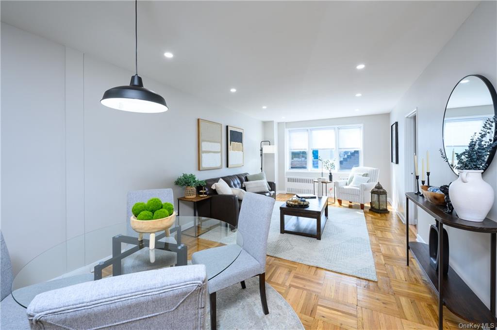 Living room featuring radiator heating unit and light parquet floors