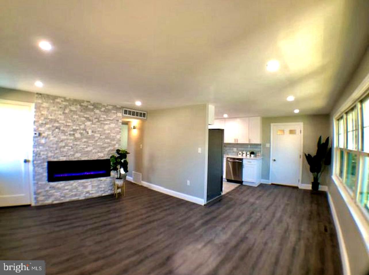 a view of empty room with wooden floor and fireplace