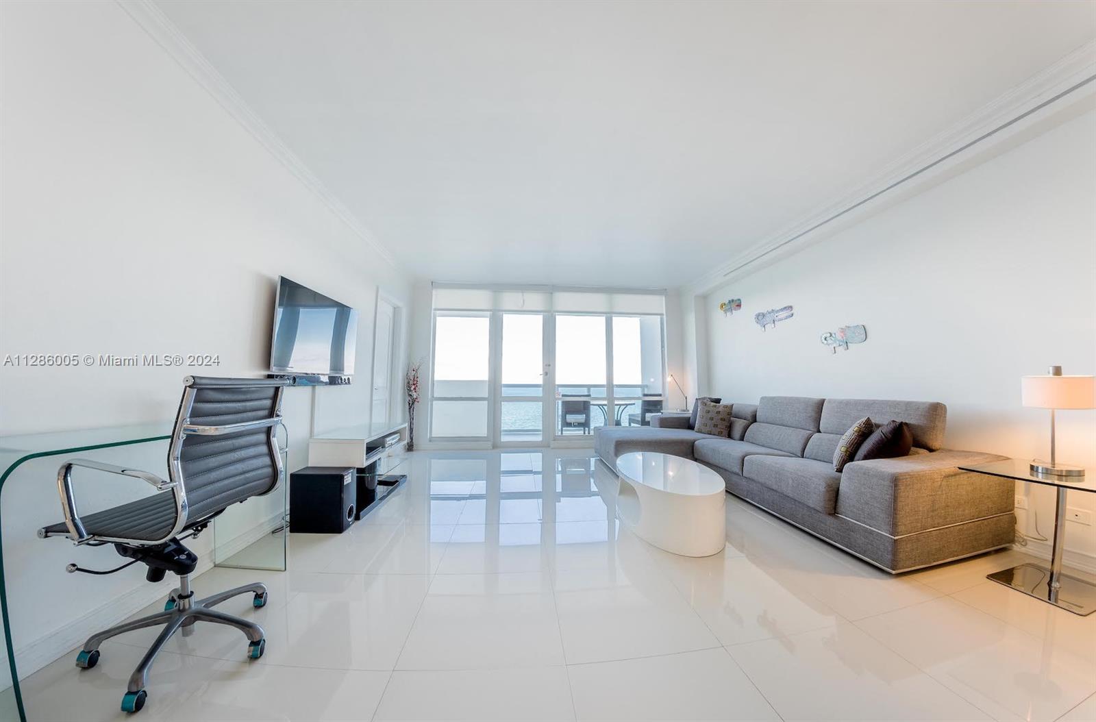 a living room with furniture a flat screen tv and a window