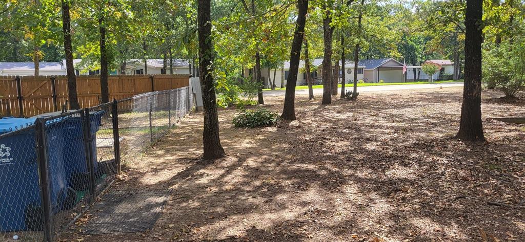 a view of a yard with wooden fence