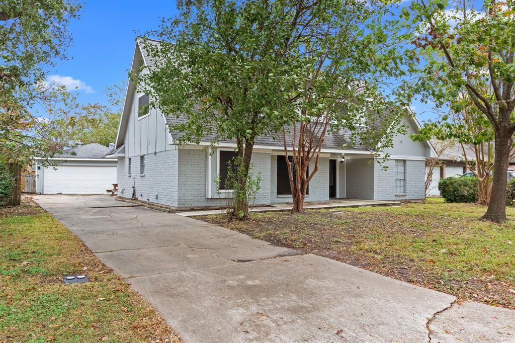 front view of a house with a yard and an trees