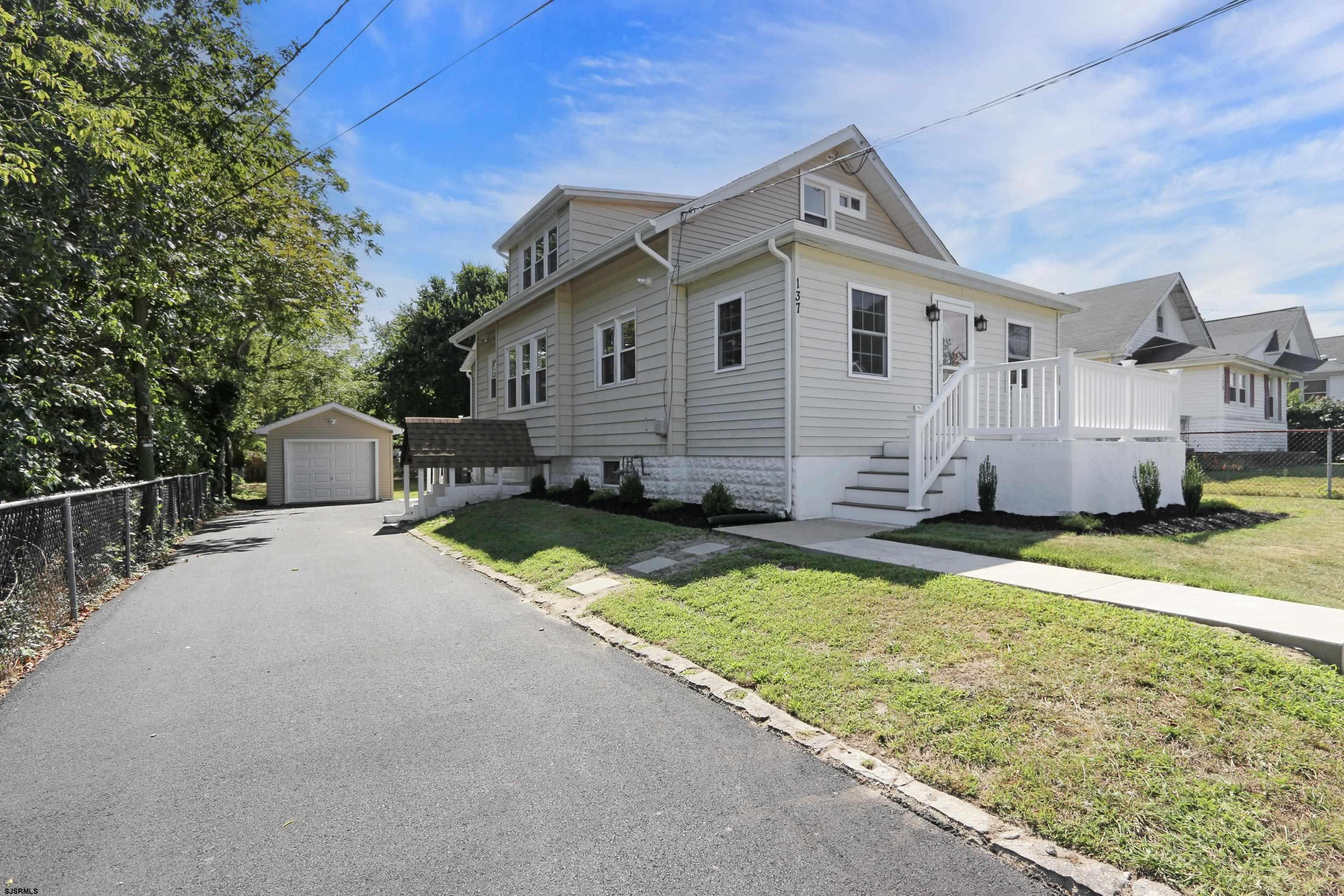 a front view of house with yard and trees in the background