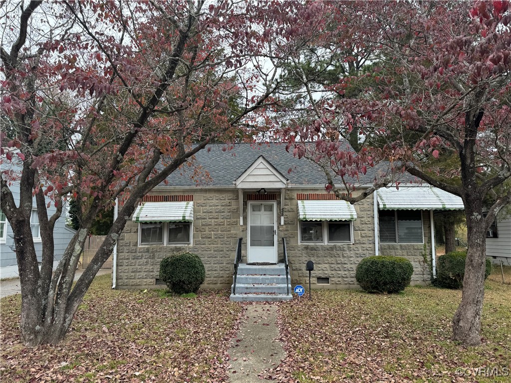 a front view of a house with yard tree and glass windows