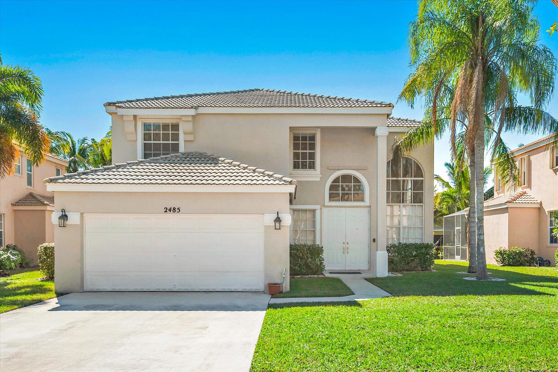 a front view of a house with a yard and a garage