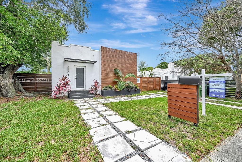 a view of a backyard with wooden fence and a bench