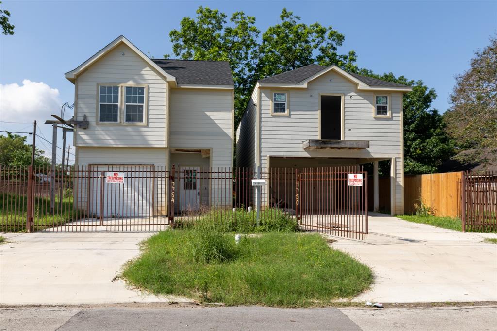 a front view of a house with a yard and potted plants