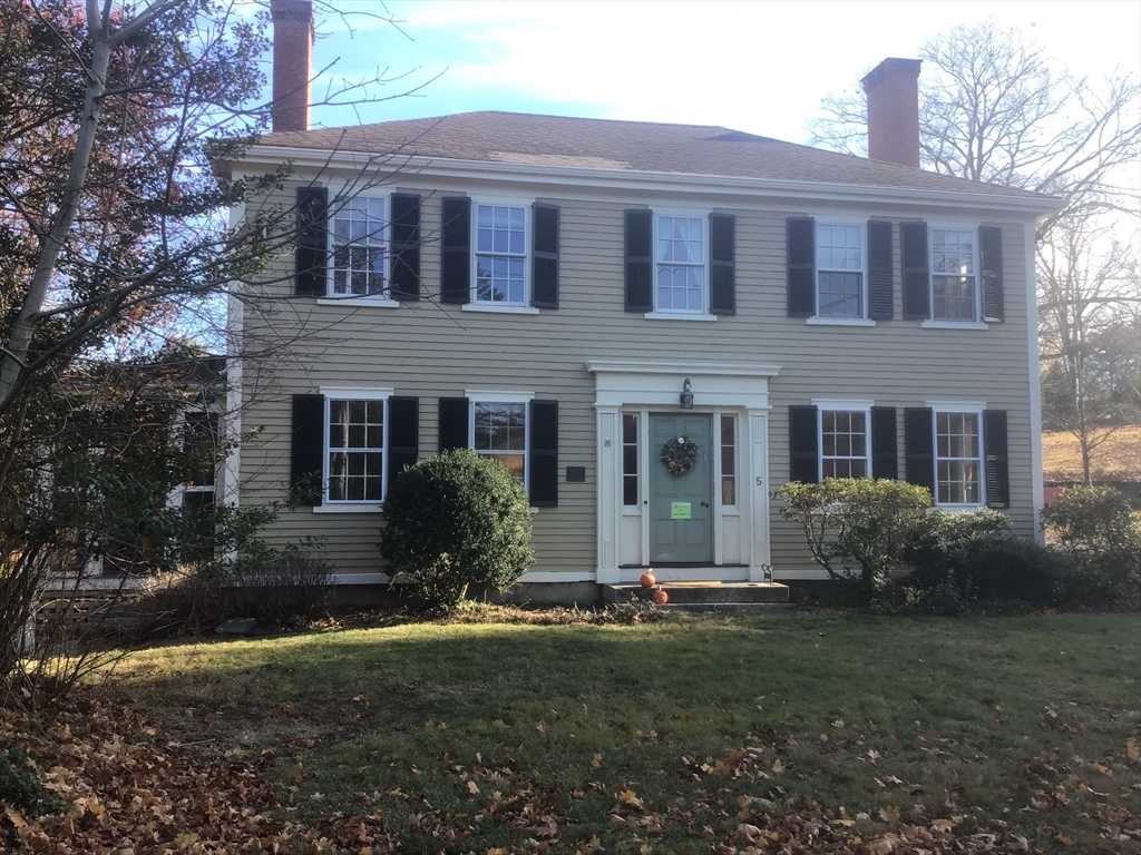 a front view of a house with yard and green space