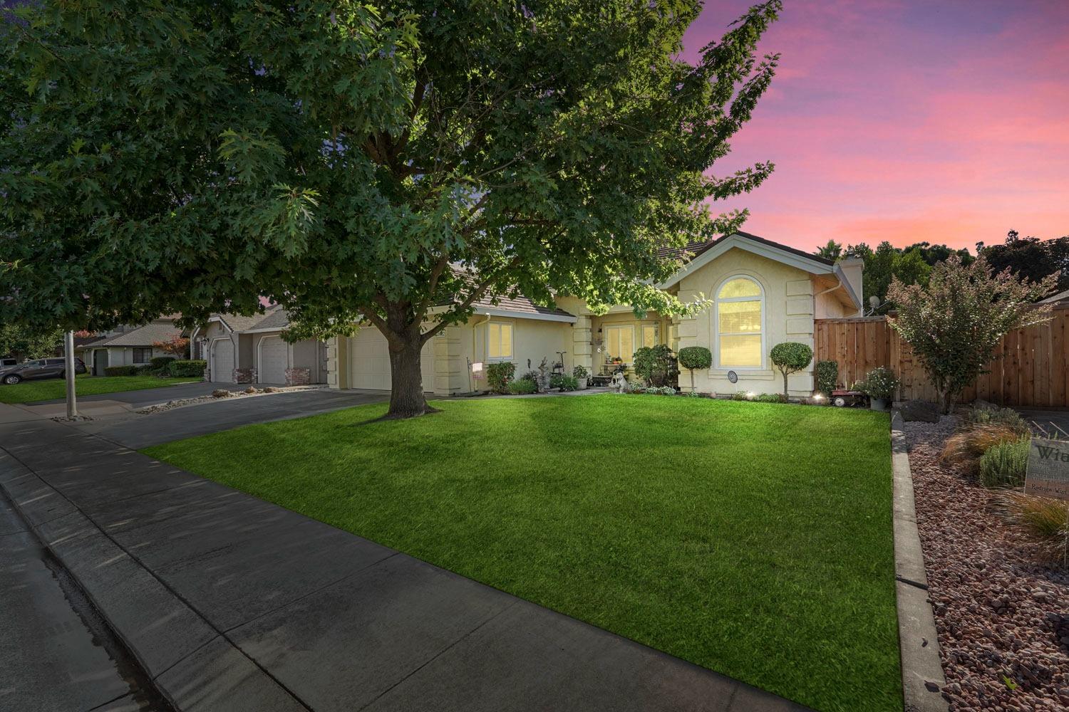 a front view of a house with a yard and trees