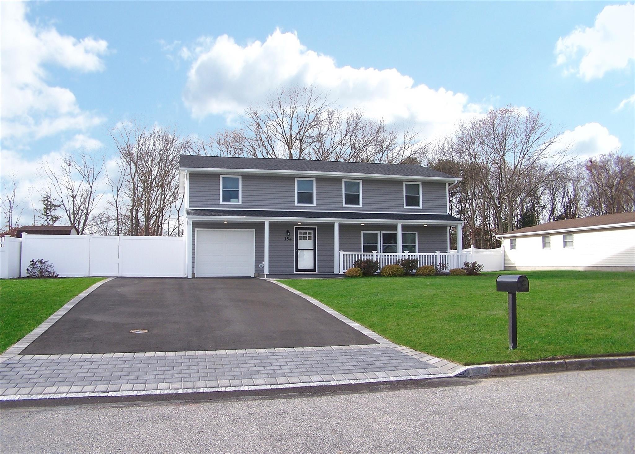 Front of property with a porch, a garage, and a front yard