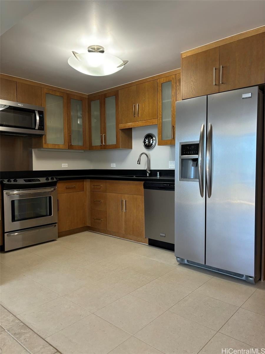 a kitchen with stainless steel appliances granite countertop a refrigerator a sink a stove and island