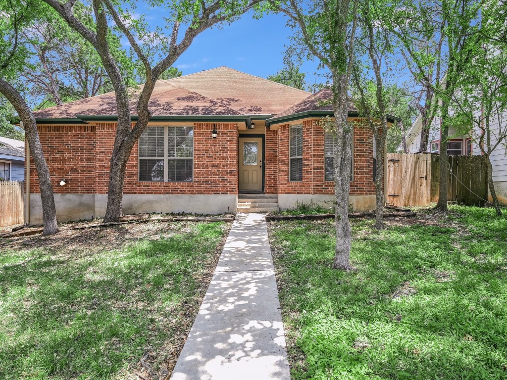 a front view of a house with yard and green space