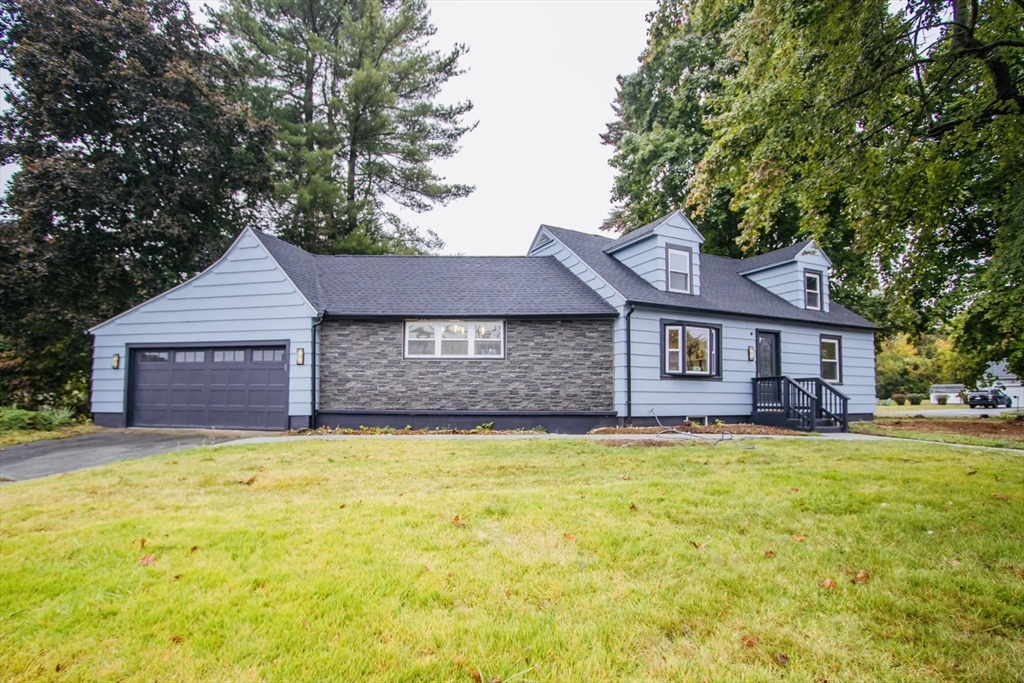 a front view of a house with yard and trees