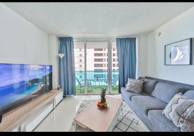 a living room with furniture and a floor to ceiling window