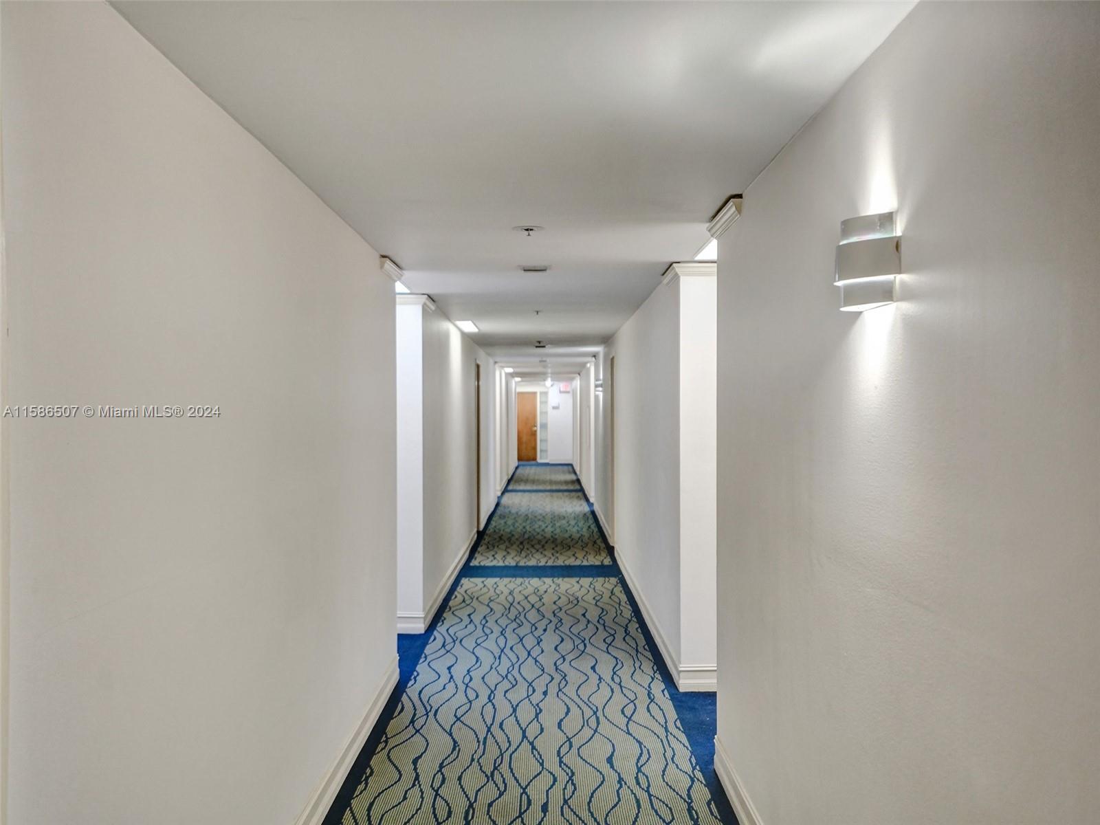 a view of a hallway with wooden floor and stairs