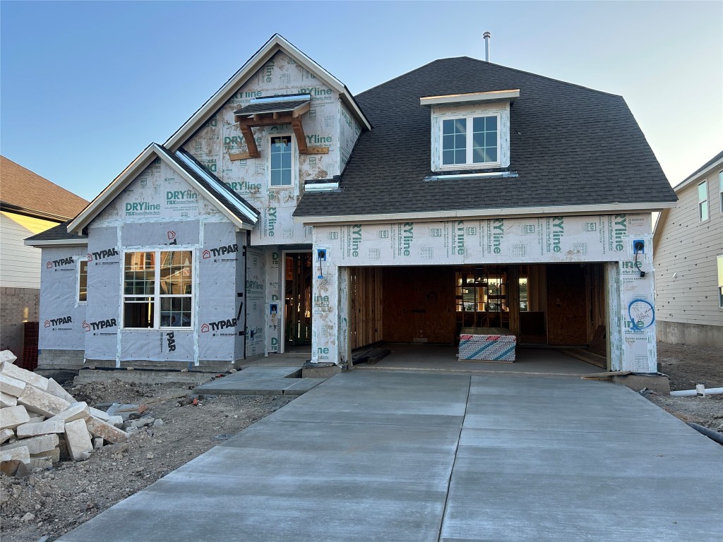 a front view of a house with yard and parking space