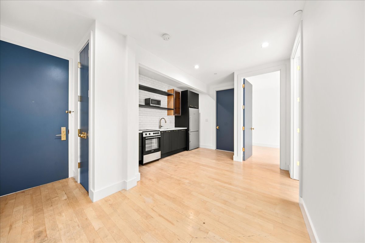 a view of a kitchen with refrigerator and window