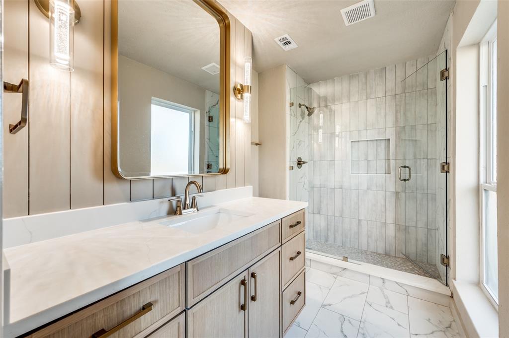 a bathroom with a shower sink and mirror