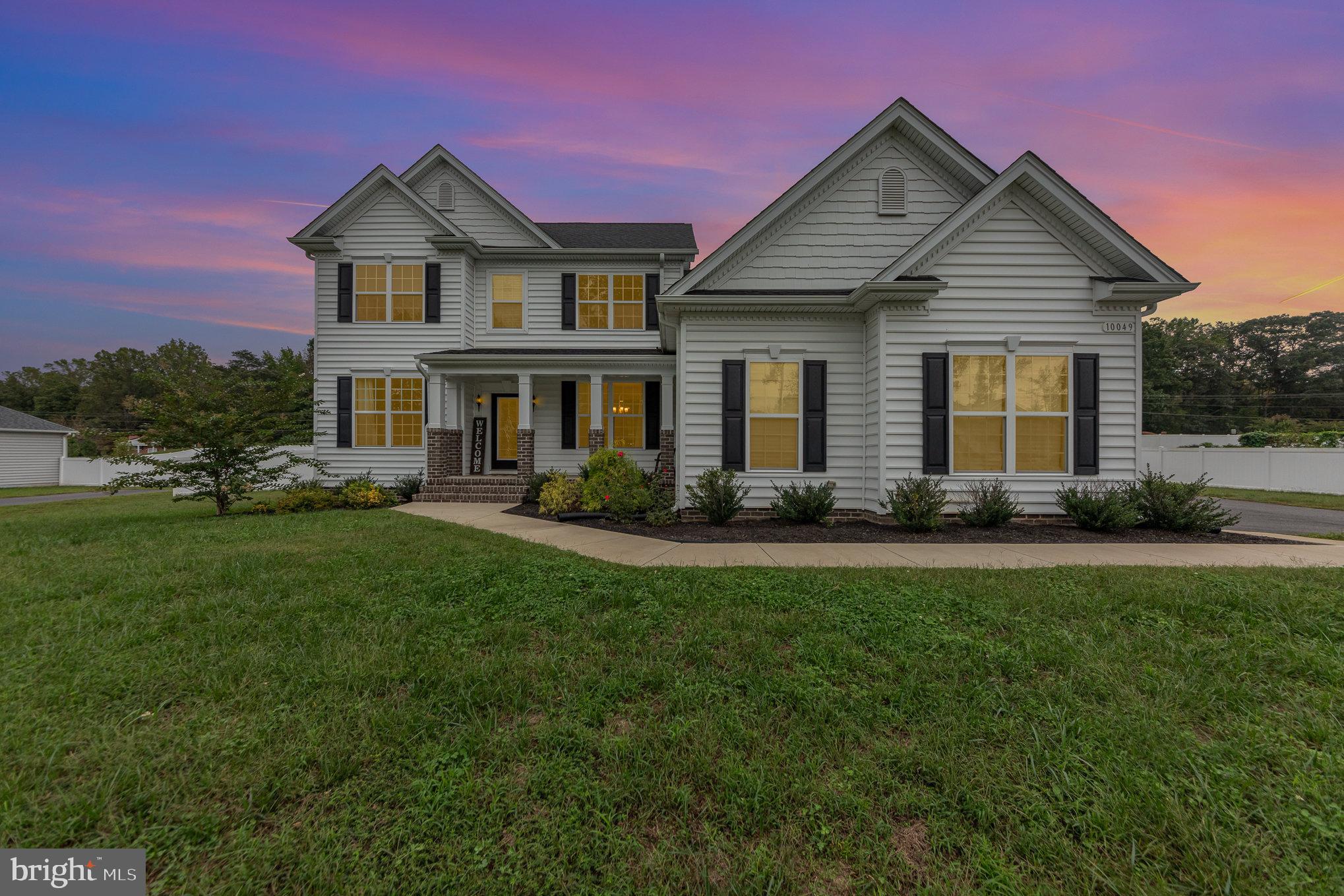 a front view of a house with a yard and green space