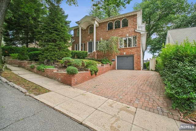 a front view of a house with a yard and a garden