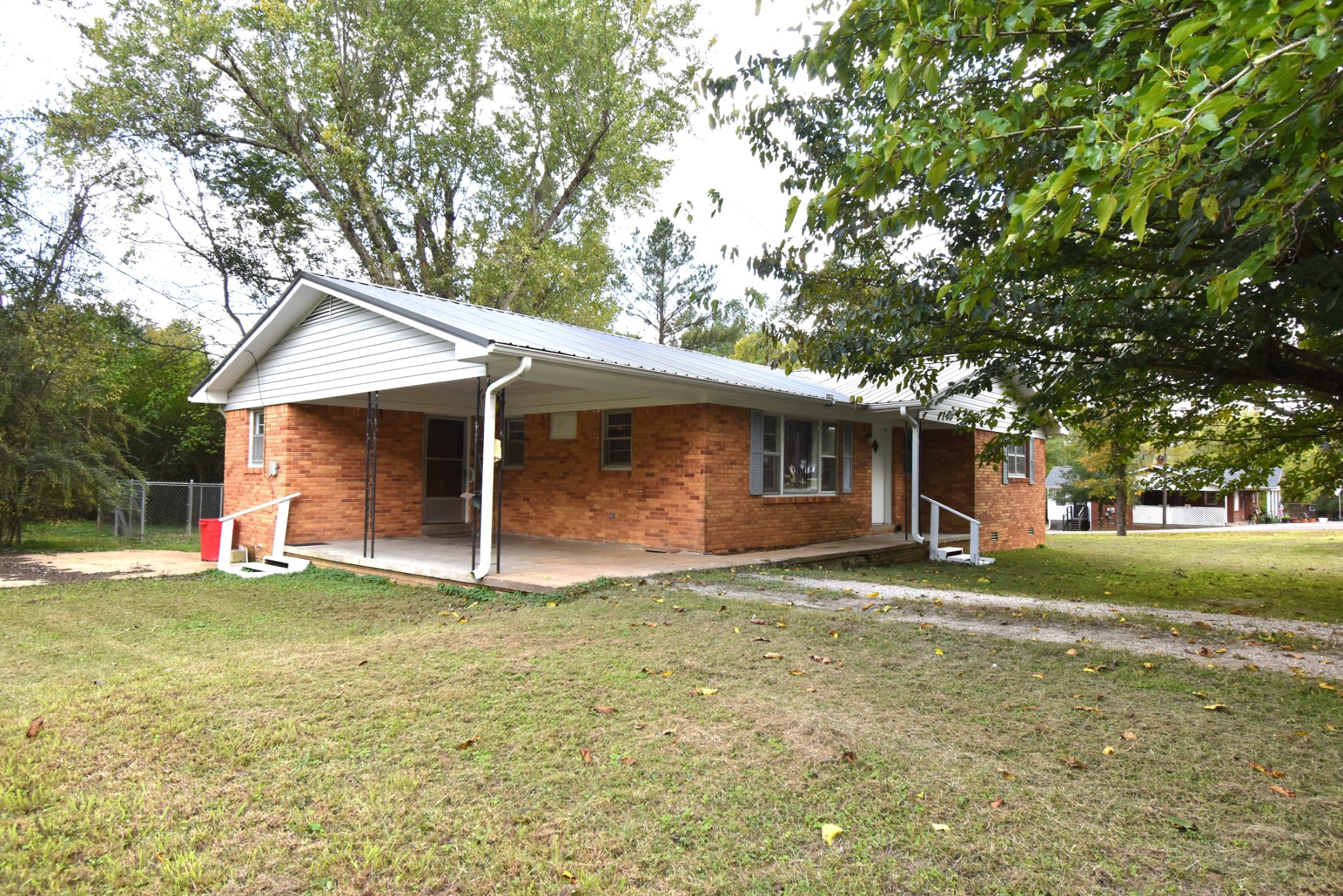 a front view of a house with a garden and trees