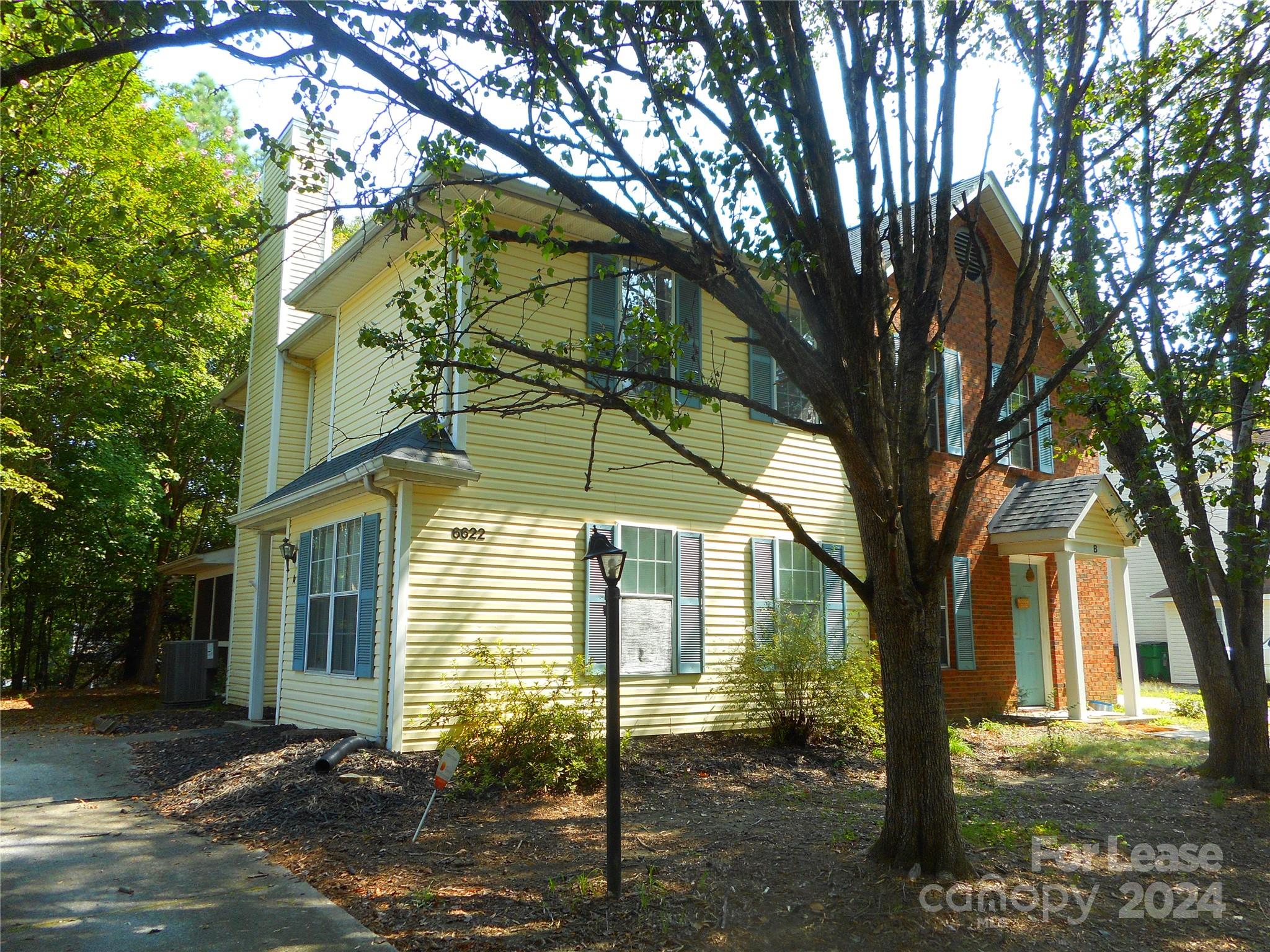 a front view of a house with a tree