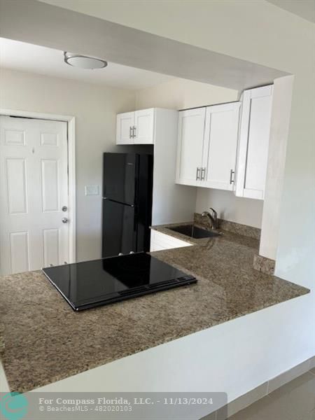 a view of a refrigerator a sink and dishwasher