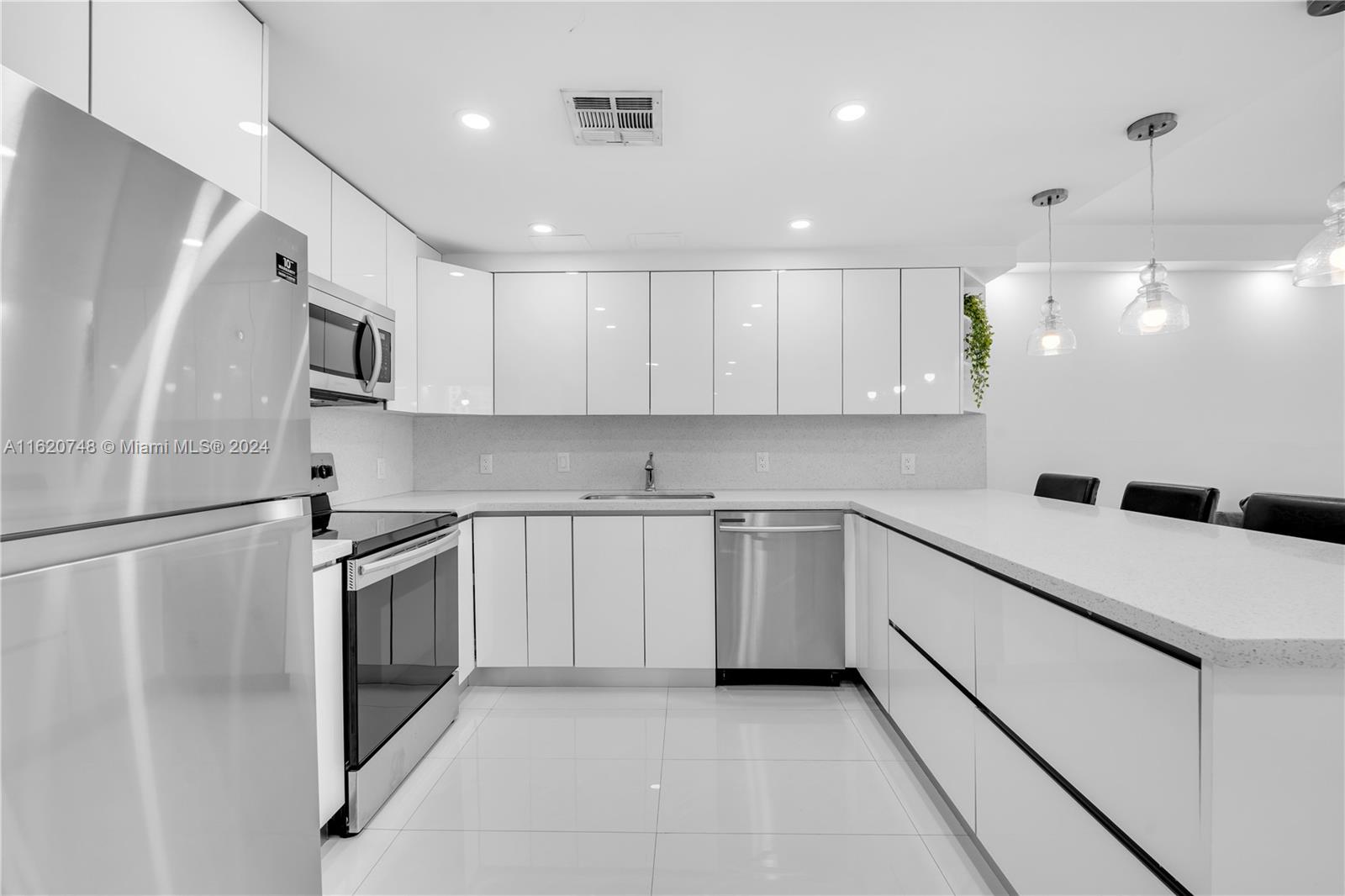 a kitchen with stainless steel appliances a refrigerator sink and microwave