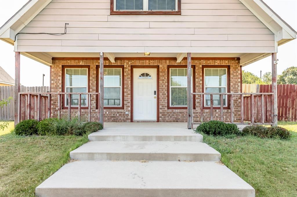 View of front of house with a porch and a front yard