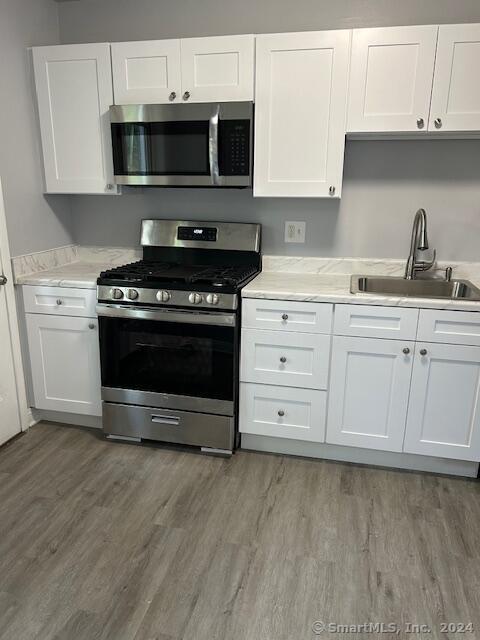 a kitchen with stainless steel appliances a stove a sink and a microwave