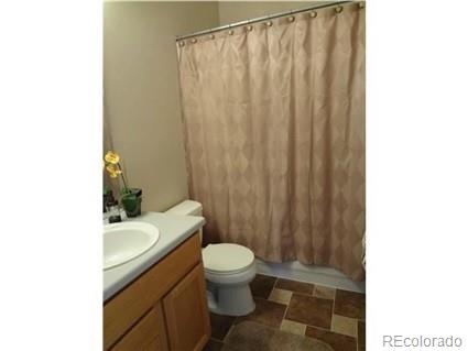 a bathroom with a sink a toilet and shower curtain