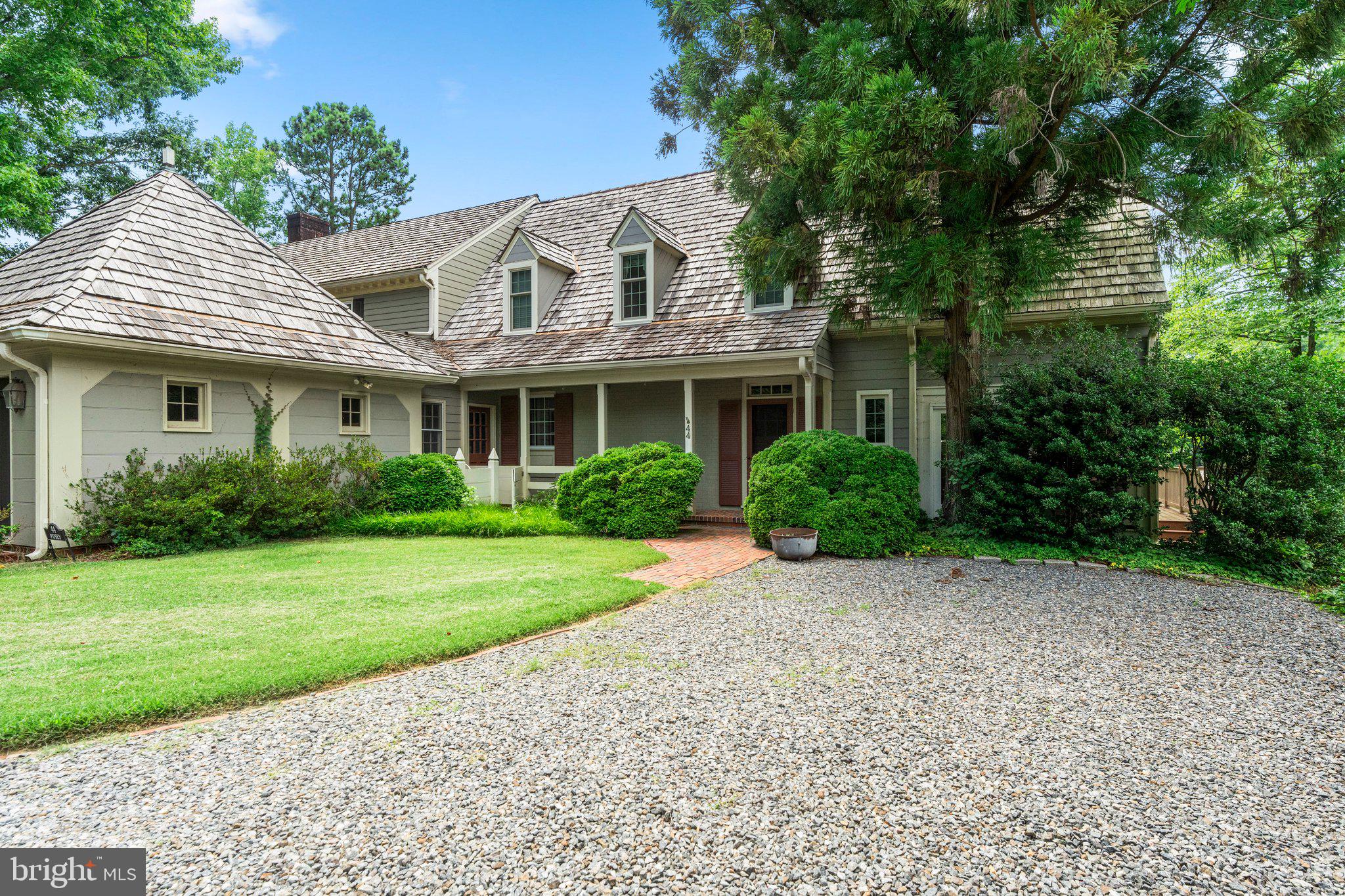 a front view of a house with a yard and potted plants