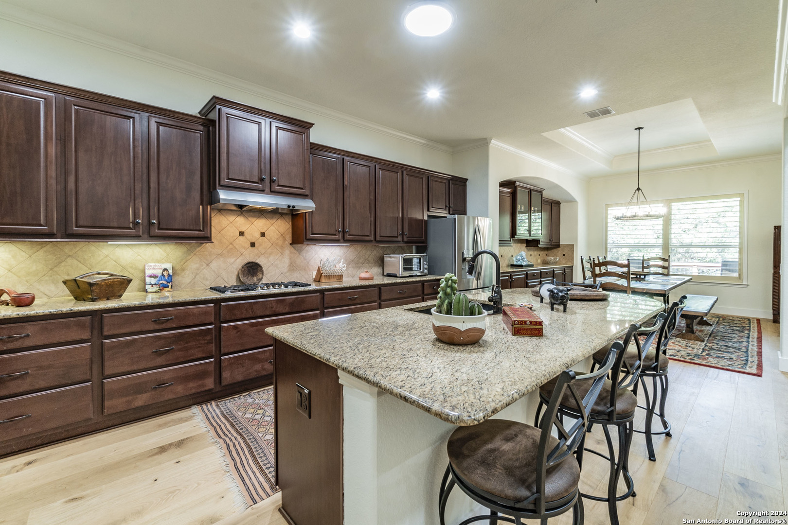 a kitchen with a sink a stove and chairs