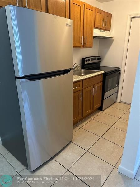 a white refrigerator freezer and a stove sitting inside of a kitchen