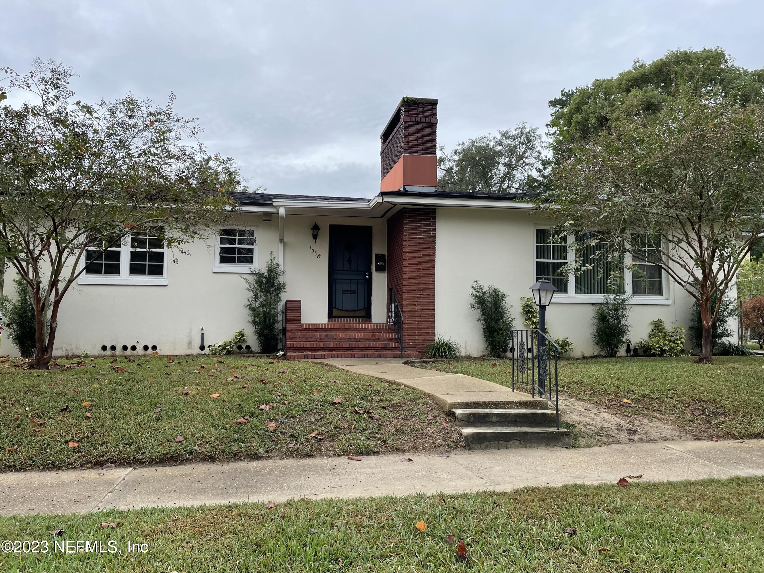 a view of a house with backyard and trees