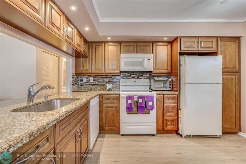 a kitchen with stainless steel appliances granite countertop a refrigerator and a sink