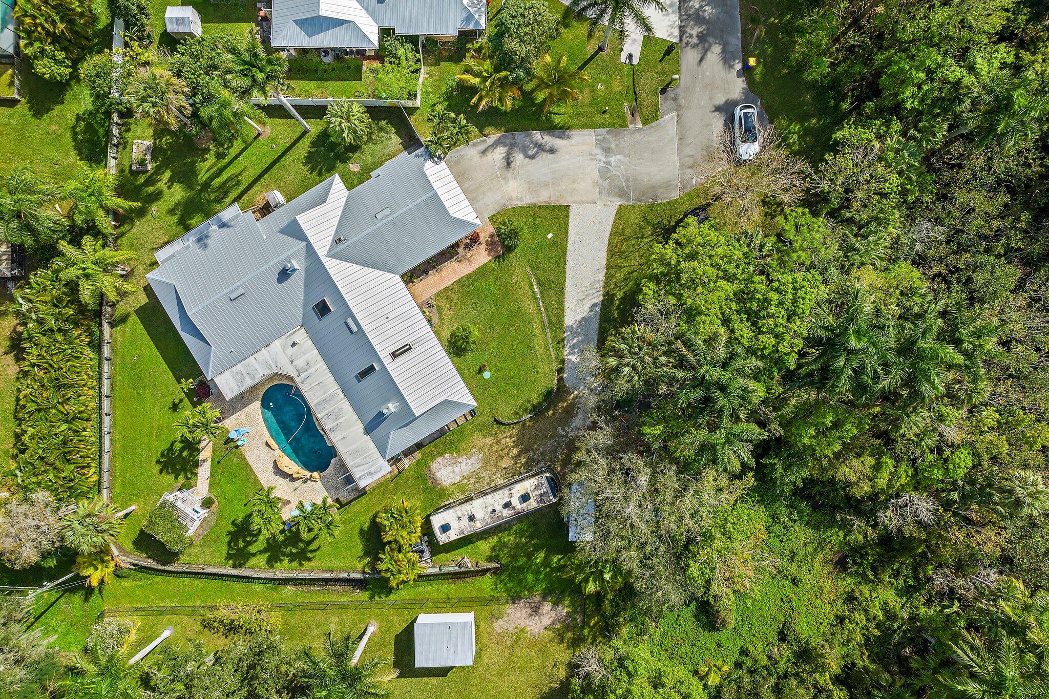 an aerial view of a house with a yard and trees