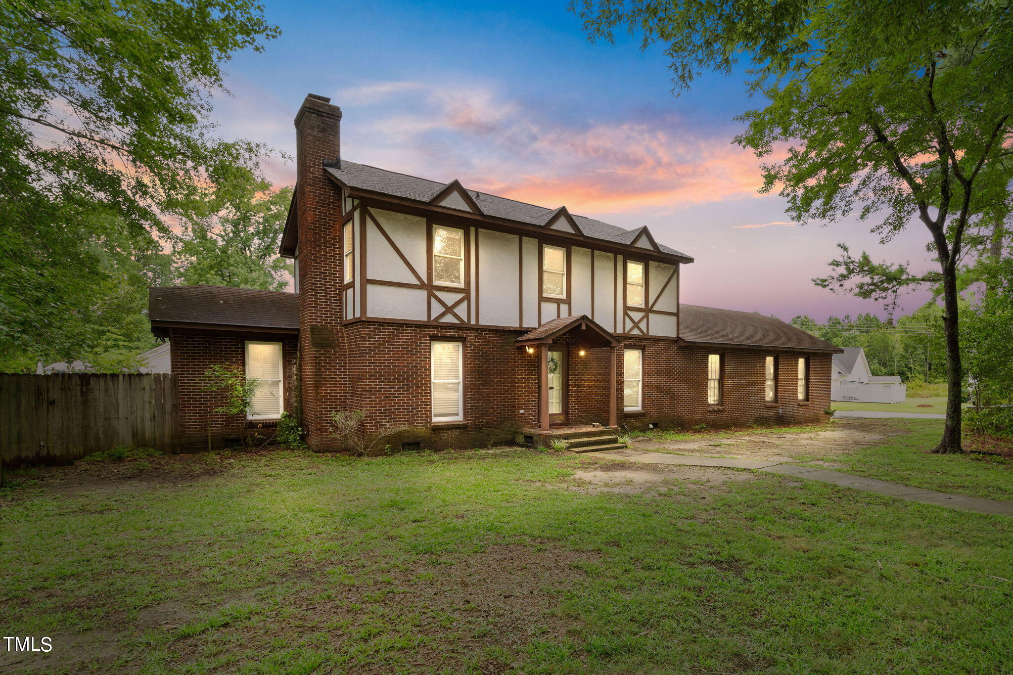 a front view of a house with a yard and trees