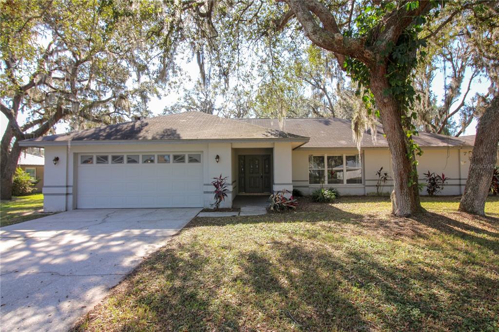 a view of a house with a patio and a yard