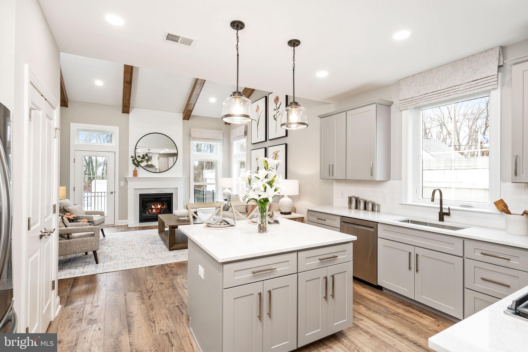 a kitchen with a sink dishwasher a stove and a clock on the wall with a large window