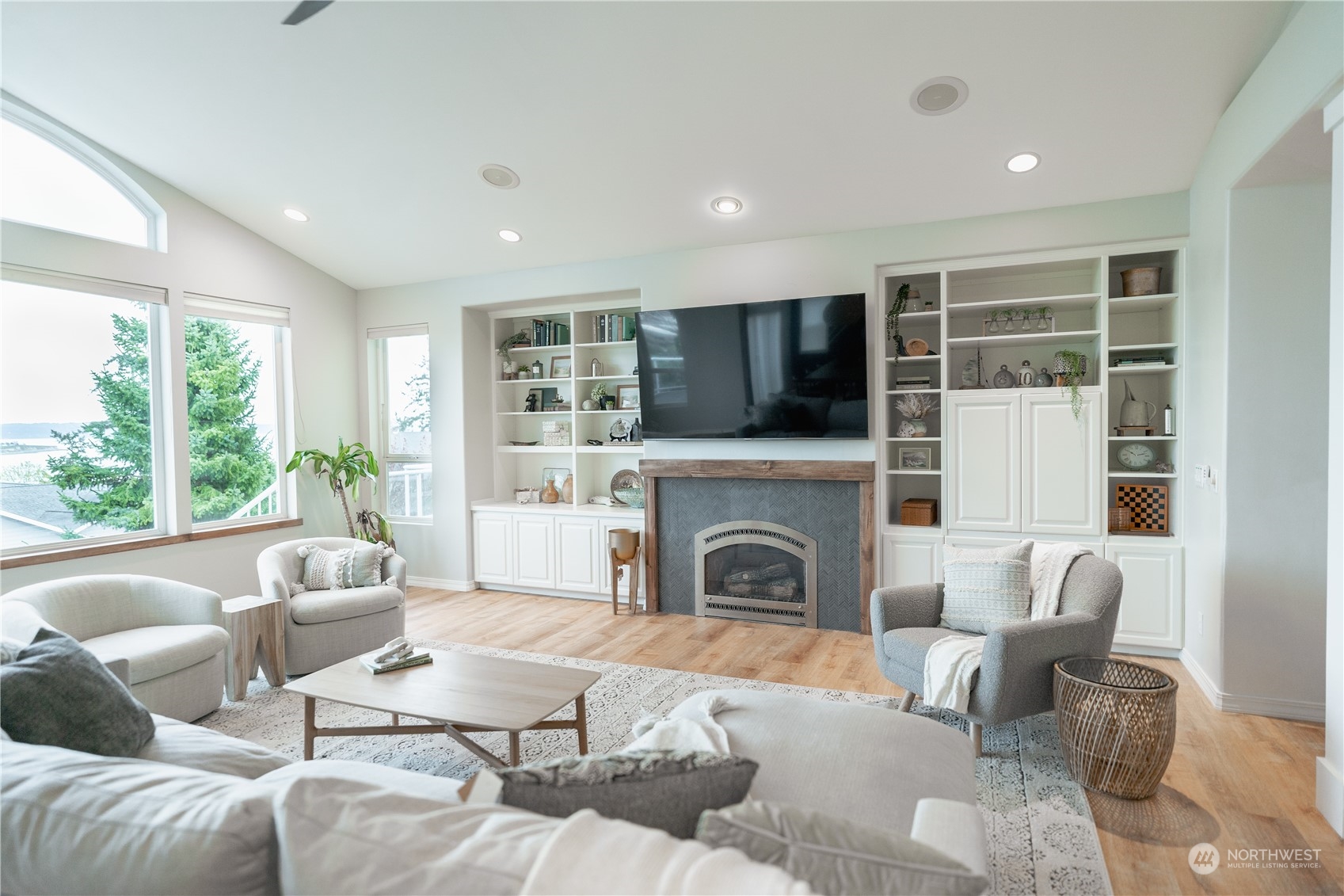 a living room with furniture a fireplace and a floor to ceiling window