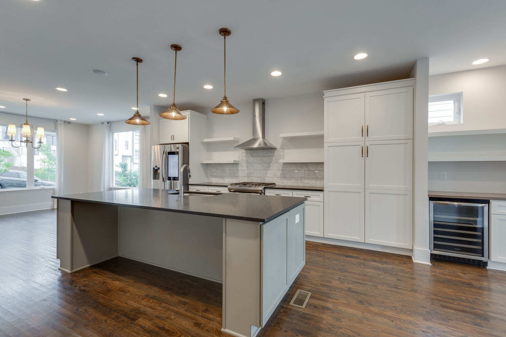 a kitchen with stainless steel appliances granite countertop a sink a stove and a wooden floors