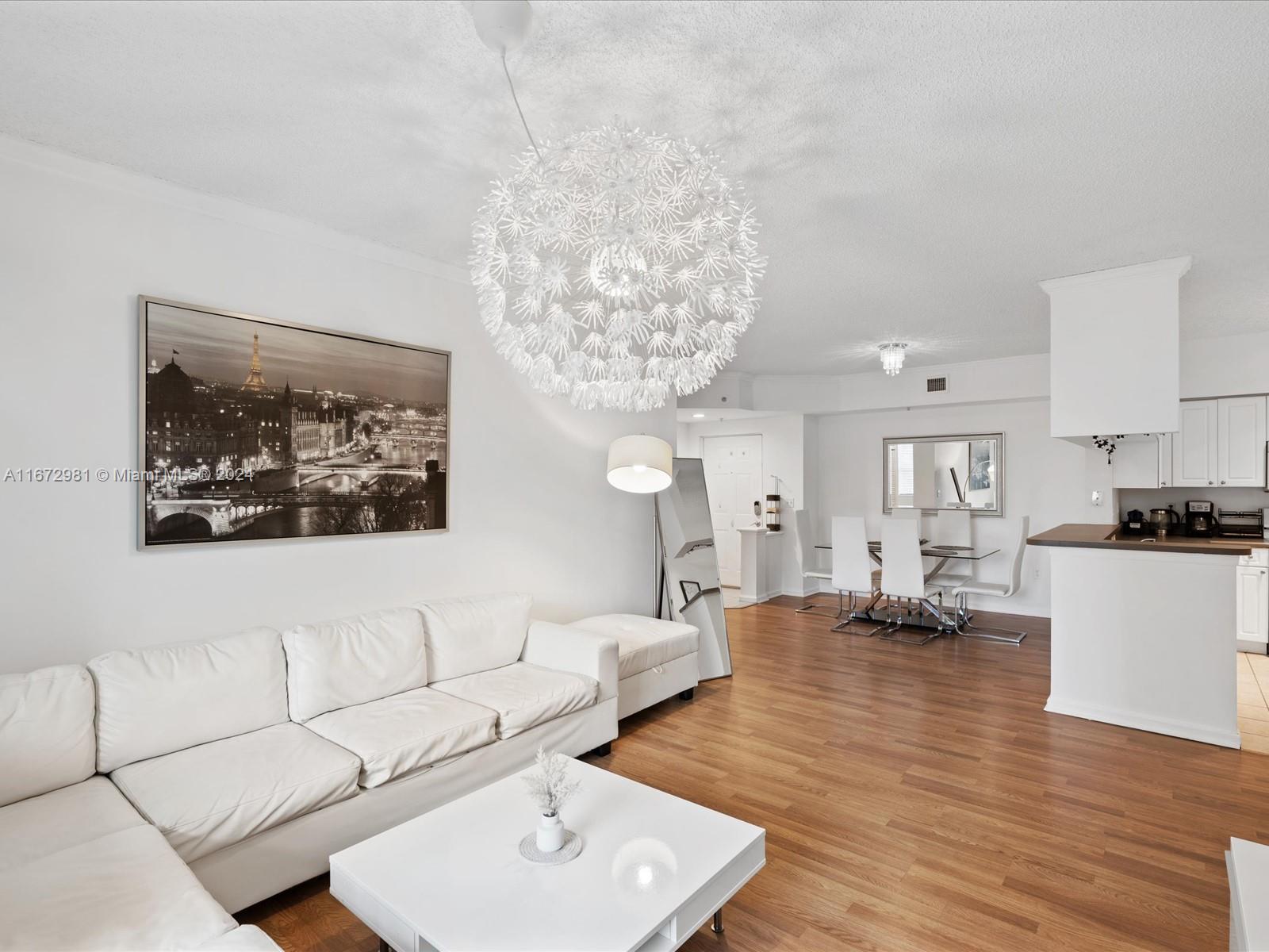 a living room with furniture and a chandelier