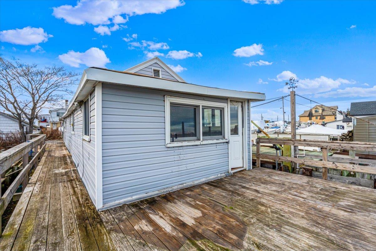 View of property exterior featuring a wooden deck